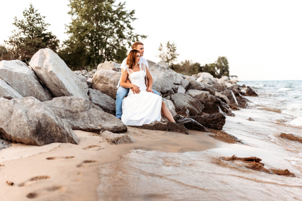 Family Photography, Couple sitting on rocks looking out towards the water