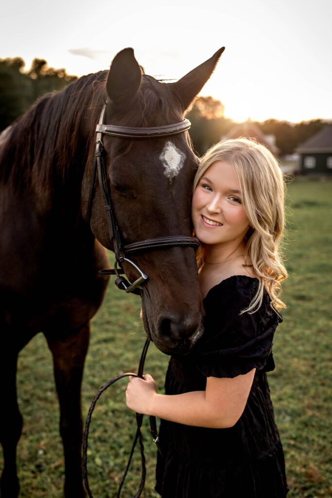 Senior Photography, Girl in black dress standing next to her horse in a field